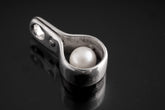 Polished sterling silver Pearl spinner pendant with luminous white Pearl sphere inside a sculptural silver wrap.