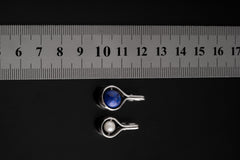 Pearl spinner pendant shown beside a ruler for scale, with polished sterling silver wrap and integrated bail.