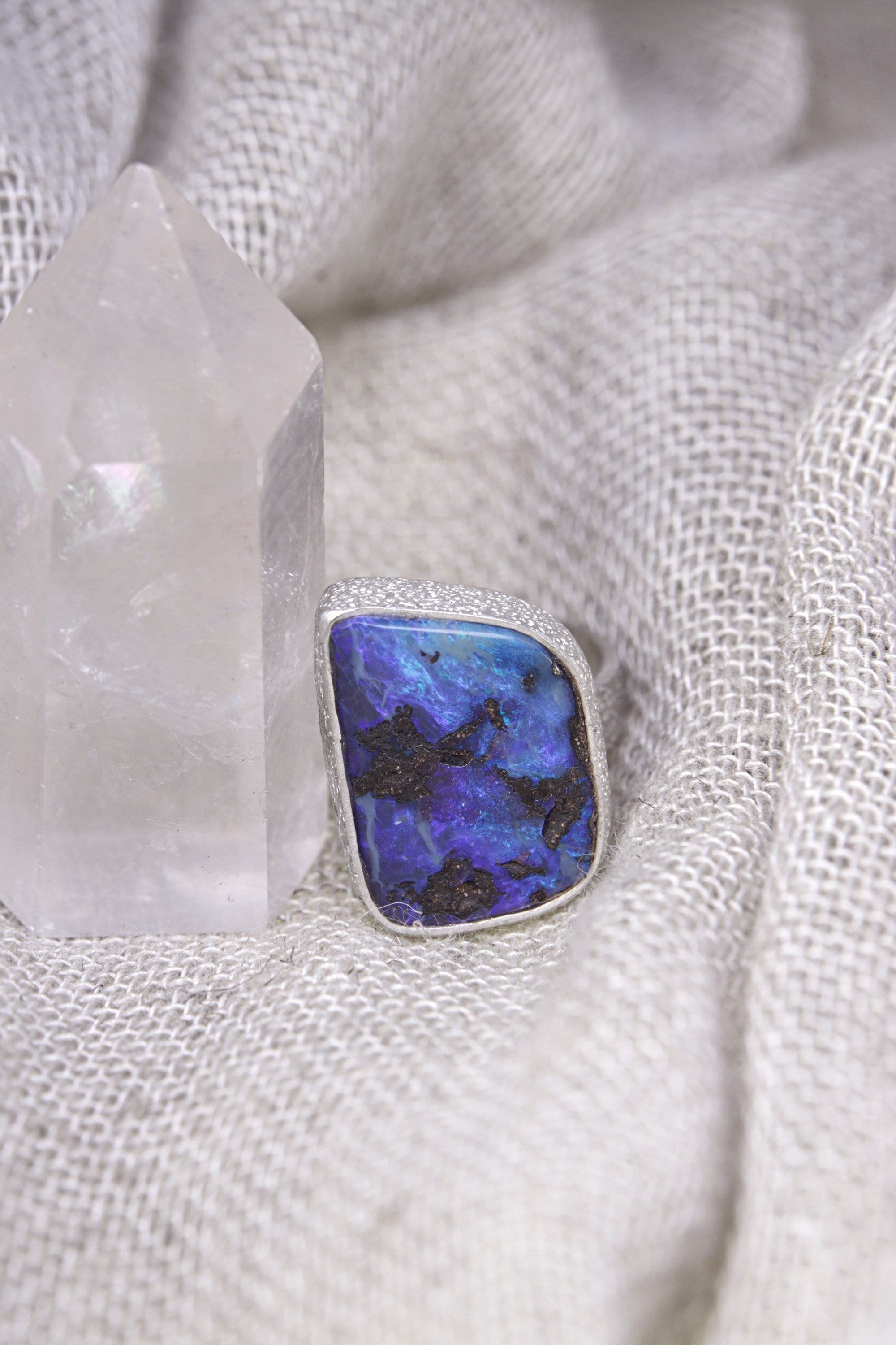 Square-cut Opal ring shown on soft fabric, with high-shine sterling silver and luminous internal colour flashes.