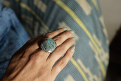 Australian Turquoise ring shown worn on the hand, with textured sterling silver band and blue-green stone surface.