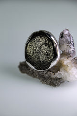 Pyrite adjustable ring shown beside quartz crystal, with metallic golden stone and high-shine sterling silver setting.