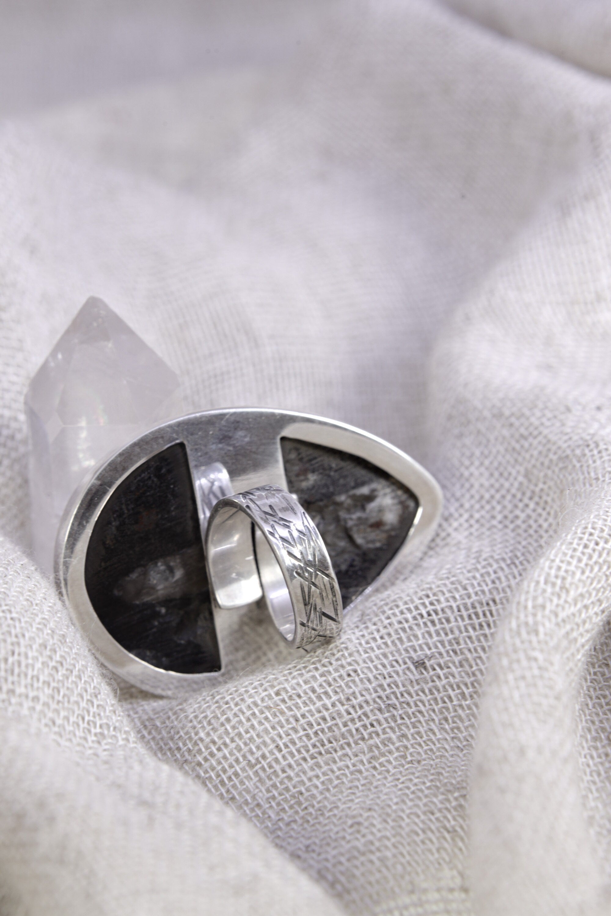 Side view of adjustable fossil ring showing the high-shine sterling silver band, waved bezel, and open ring construction.