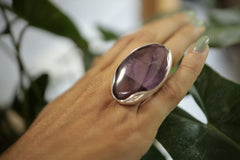 Oval Amethyst ring shown worn on the hand, with high-shine sterling silver band and rich purple stone centrepiece.