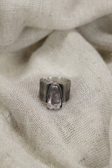 Vera Cruz Amethyst ring shown on soft fabric, with oxidized sterling silver and delicate purple crystal centrepiece.