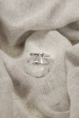 Amethyst Embrace Ring shown on fabric with open double-stone silver design and delicate Vera Cruz Amethyst.