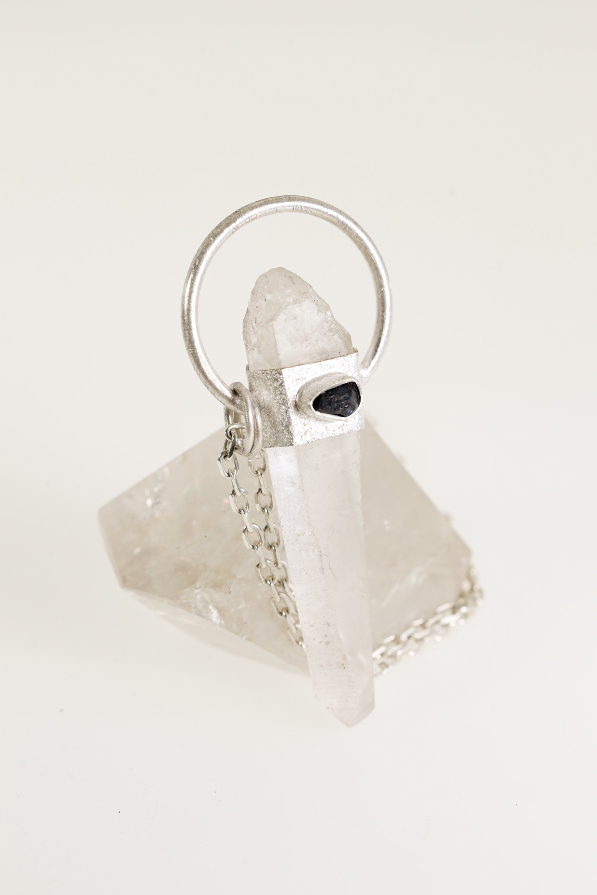 Australian Lemurian Quartz Sapphire Halo Pendant shown on light background with sand-textured sterling silver halo and clear crystal point.