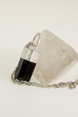 Brown Dravite Tourmaline Diamond pendant shown with clear quartz display crystal, sterling silver chain, and textured silver setting.