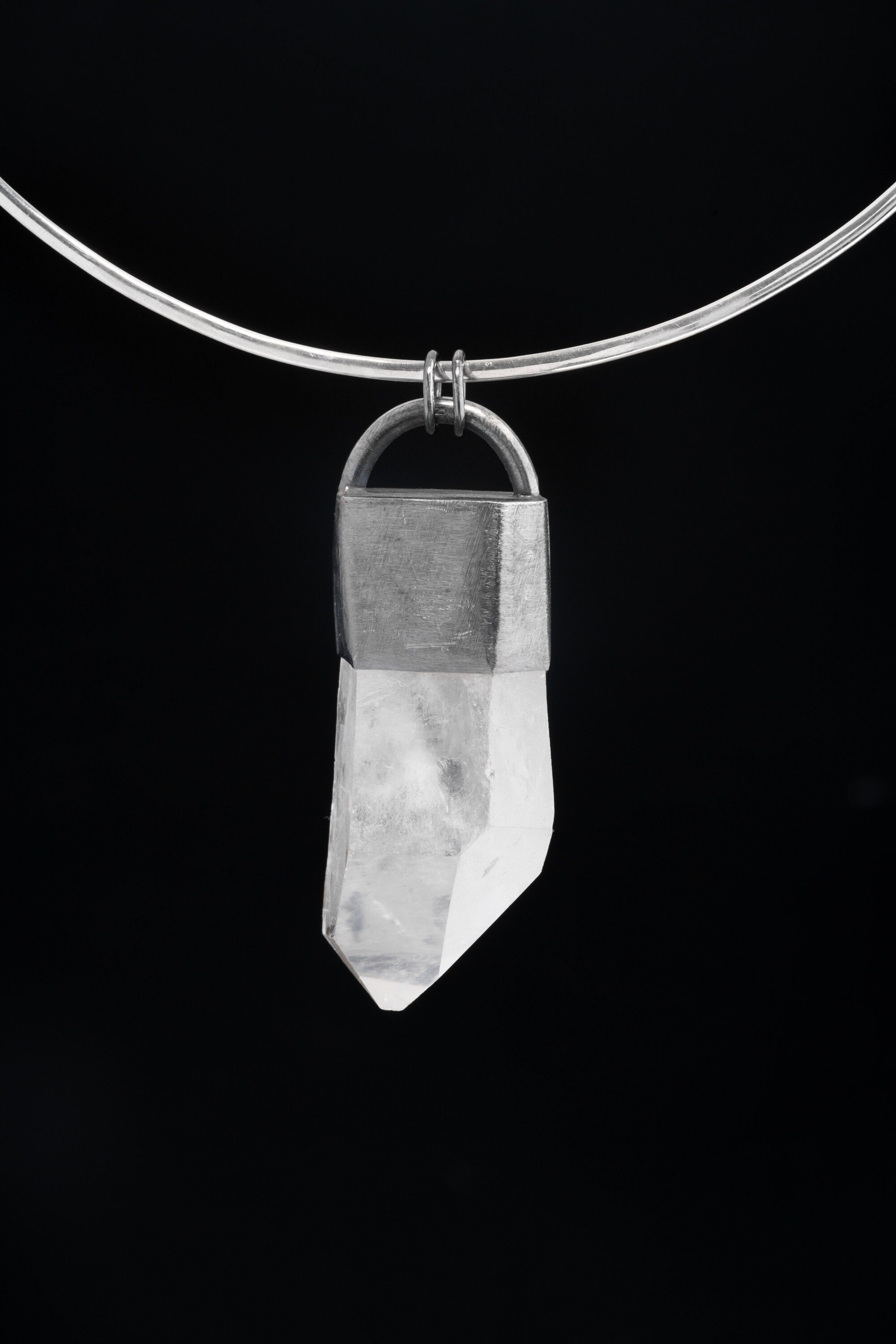 Clear Quartz Halo pendant shown on black cord, with polished 925 sterling silver frame and large transparent crystal point.