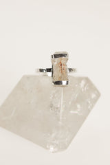 Raw Australian Aquamarine ring displayed on clear quartz, with oxidized sterling silver setting and natural blue beryl crystal.