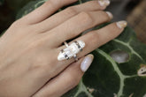 Mother of Pearl oxidized sterling silver ring shown worn on the hand, with iridescent nacre stone and hammered band.