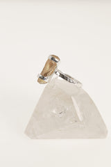 Side view of handmade Amber fossil ring on clear quartz, with polished sterling silver setting and warm organic stone.
