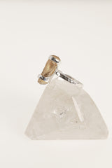 Side view of handmade Amber fossil ring on clear quartz, with polished sterling silver setting and warm organic stone.