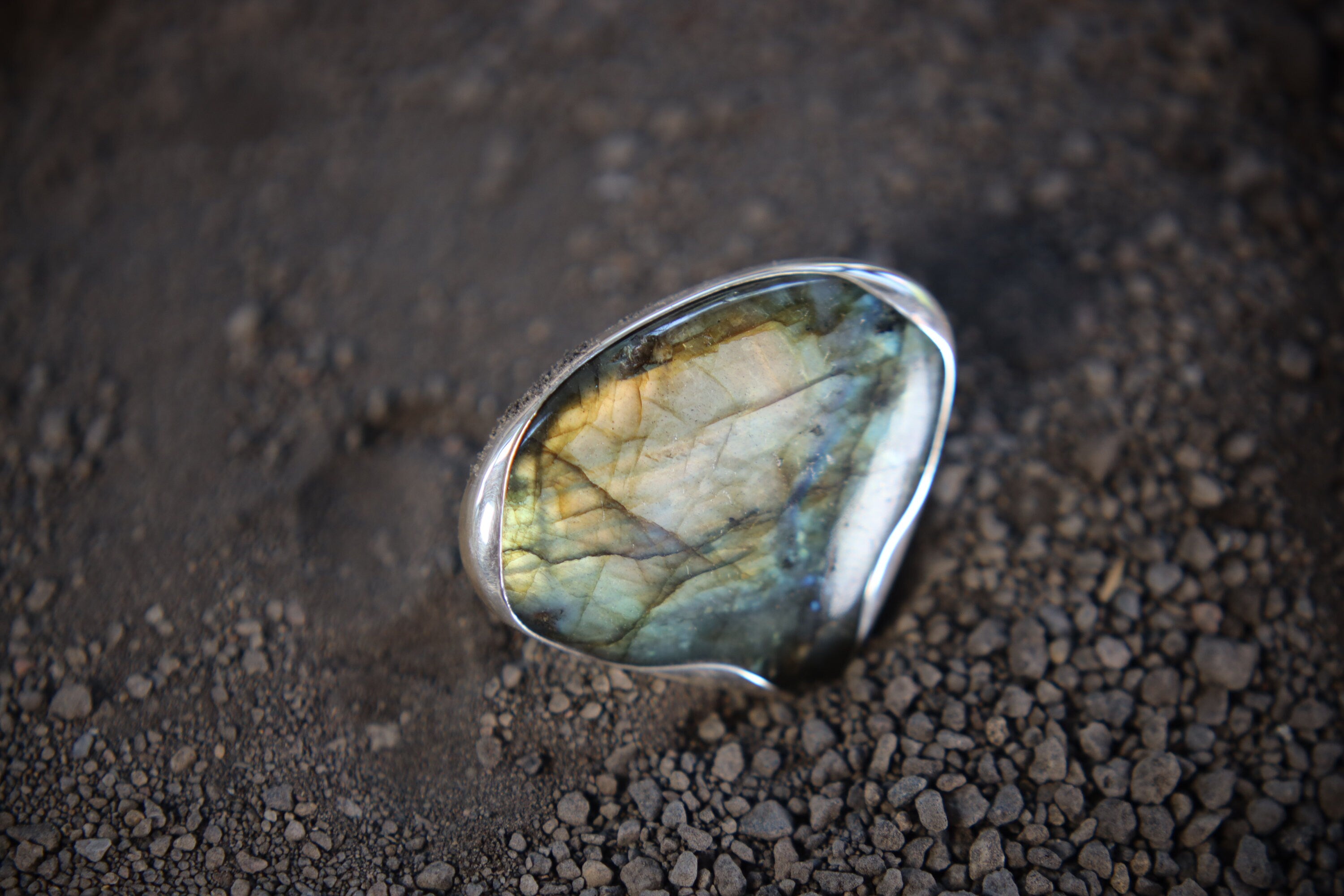 Teardrop Labradorite adjustable ring in high-shine 925 sterling silver shown close-up with blue-green and gold flash.
