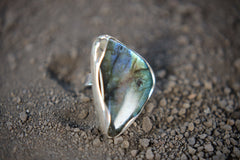 Triangular Labradorite adjustable ring shown on textured earth, with polished 925 silver and strong geometric stone shape.