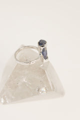 Australian Ocean Kyanite ring displayed on clear quartz, showing oxidized silver band and vertical blue gemstone setting.