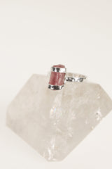 Raw Pink Tourmaline sterling silver ring displayed on clear quartz, with hammered silver band and natural rose crystal texture.