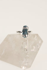 Terminated Blue Apatite ring shown on clear quartz, with hammered oxidized sterling silver and bright azure stone.