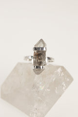 Tibetan Double Terminated Quartz ring displayed on clear crystal, showing oxidized 925 silver band and rugged handmade setting.