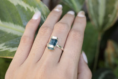 Blue Apatite sterling silver ring shown worn on the hand, with a hammered band and bright azure crystal centre stone.
