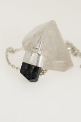 Black Tourmaline Herkimer Diamond pendant shown on black cord, with sand-textured sterling silver and arched halo bail.