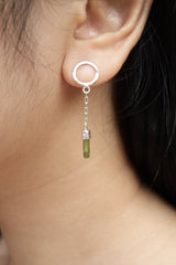 Green Tourmaline chain earrings shown worn on the ear, with round hammered silver studs and delicate raw crystal dangles.