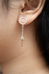 Raw Pink Tourmaline sterling silver chain earrings shown worn on the ear, with soft pink crystal drops and polished silver studs.