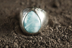 Close-up of Larimar cabochon ring showing soft blue colour, white ocean-like patterning, and polished sterling silver setting.