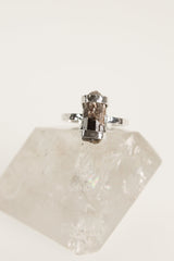 Dravite Tourmaline sterling silver ring displayed on clear quartz, with oxidized setting and honey-brown gemstone.