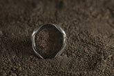 Pyrite adjustable ring in high-shine 925 sterling silver shown on earthy texture with metallic golden mineral surface.