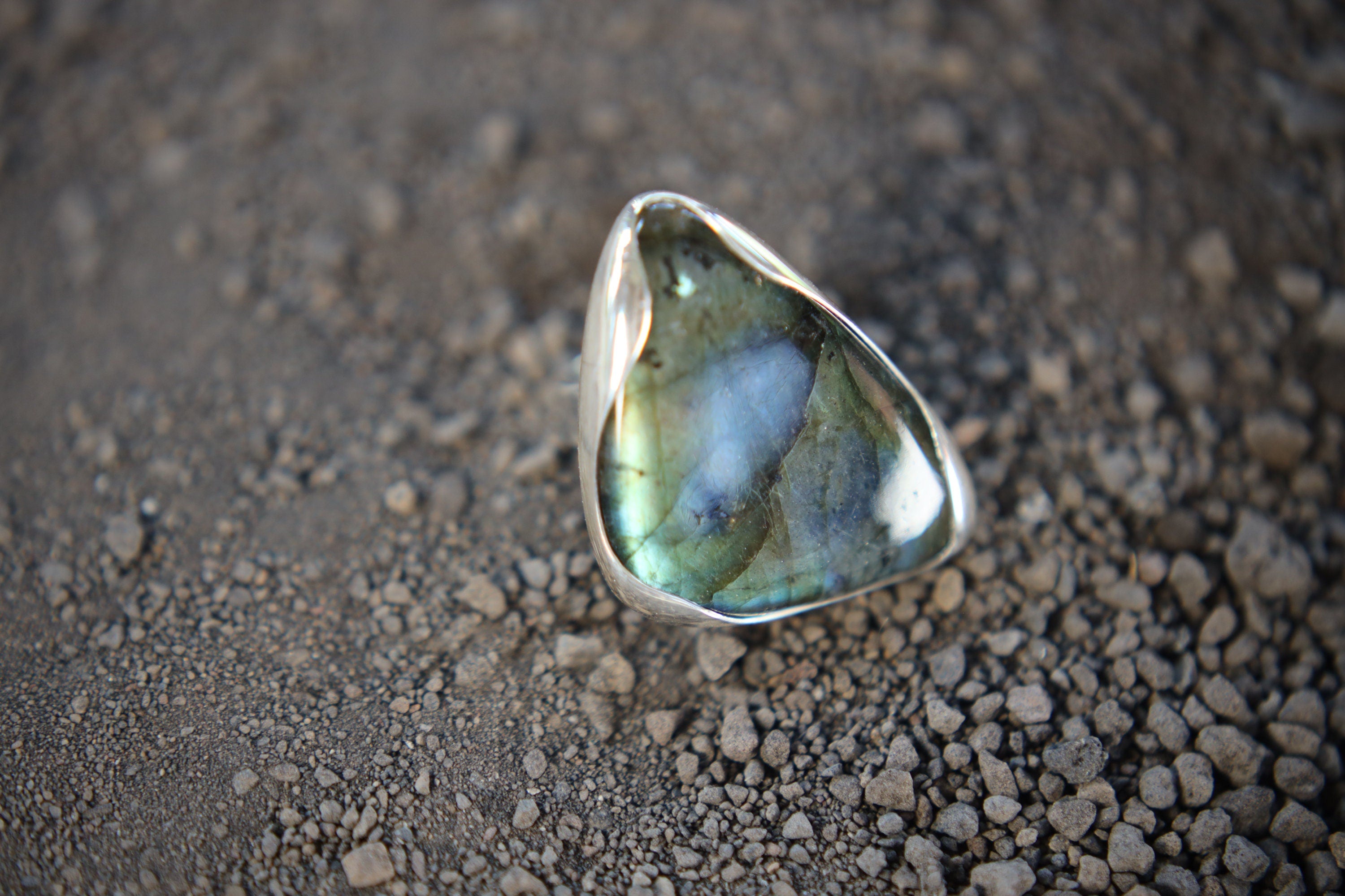 Triangular Labradorite adjustable ring in high-shine 925 sterling silver shown close-up with blue-green flash.