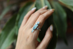 Aqua Aura Quartz Point ring shown worn on a hand, with oxidized sterling silver and luminous blue crystal setting.