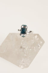Terminated Blue Apatite ring displayed on clear quartz, showing the oxidized sterling silver setting and natural blue crystal point.