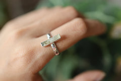 Aquamarine silver ring shown worn on a hand against leaves, with polished sterling silver and calm blue gemstone.