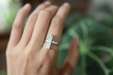 Long square cut Aquamarine silver ring shown worn on a hand, with polished hammered sterling silver and blue gemstone.