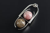 Rhodochrosite and Golden Rutile Quartz pendant in high-shine 925 sterling silver shown on a dark background with black cotton cord.