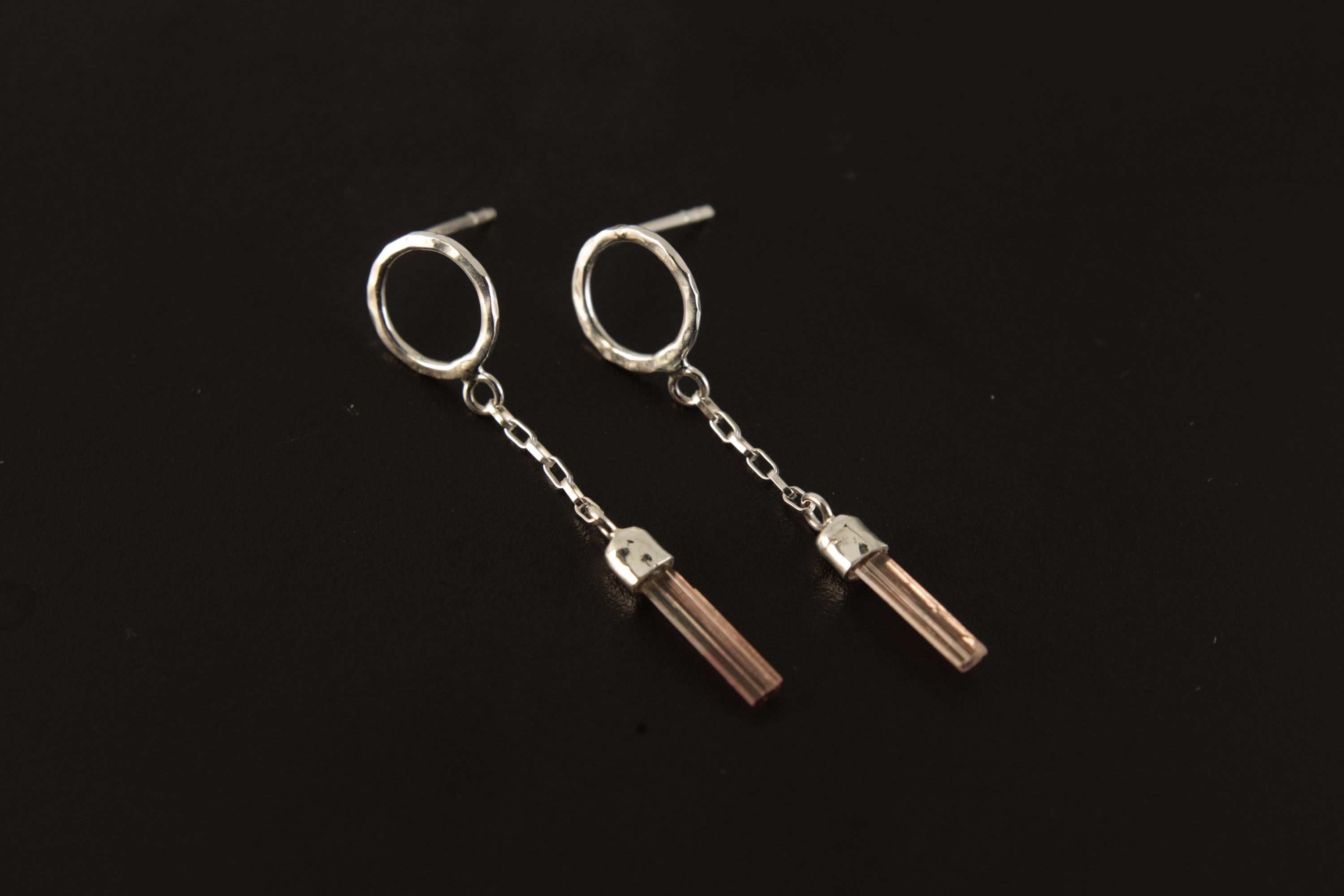 Handmade 925 sterling silver Pink Tourmaline chain earrings shown on the ear, with hammered round studs and raw crystal dangles.