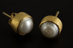 Close view of South Sea Pearl gold-plated stud earrings showing creamy pearl lustre and sand-textured settings.