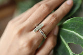 Long square cut Aquamarine silver ring shown worn on a hand, with polished hammered sterling silver and pale blue gemstone.