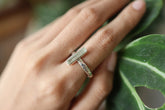 Long square cut Aquamarine silver ring shown worn on a hand, with polished hammered sterling silver and pale blue gemstone.