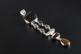 Emerald Dravite Herkimer Aquamarine Tiger Eye pendant shown on a dark background with polished sterling silver and long gemstone layout.
