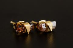 Close view of Pink Tourmaline earrings showing raw vertical crystals, triangle frames, and sand-textured gold-plated silver.