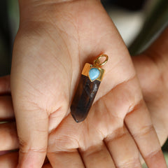 Mystic Ocean Whisper Quartz Larimar pendant held in hand showing dark Smoky Phantom Quartz and gold-plated silver cap.