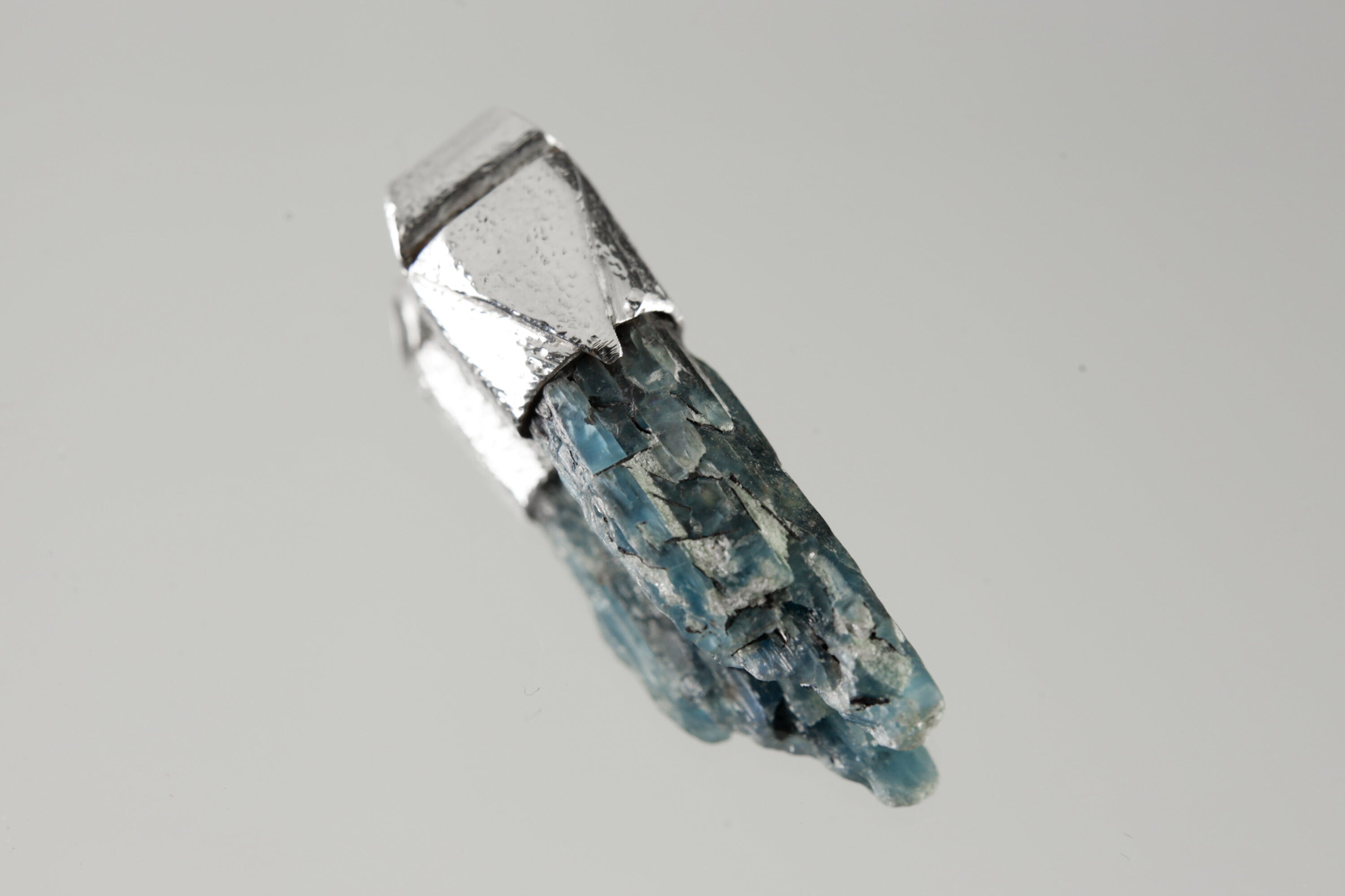 Australian Ocean Kyanite Stack Pendant shown on light background with sterling silver cap and deep blue crystal body.