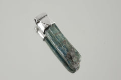 Kyanite Stack Pendant shown worn on the chest with sterling silver cap and blue bladed crystal.