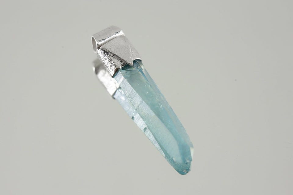 Lemurian Laser Aqua Aura Quartz Stack Pendant shown on a light background with textured sterling silver cap and blue crystal.