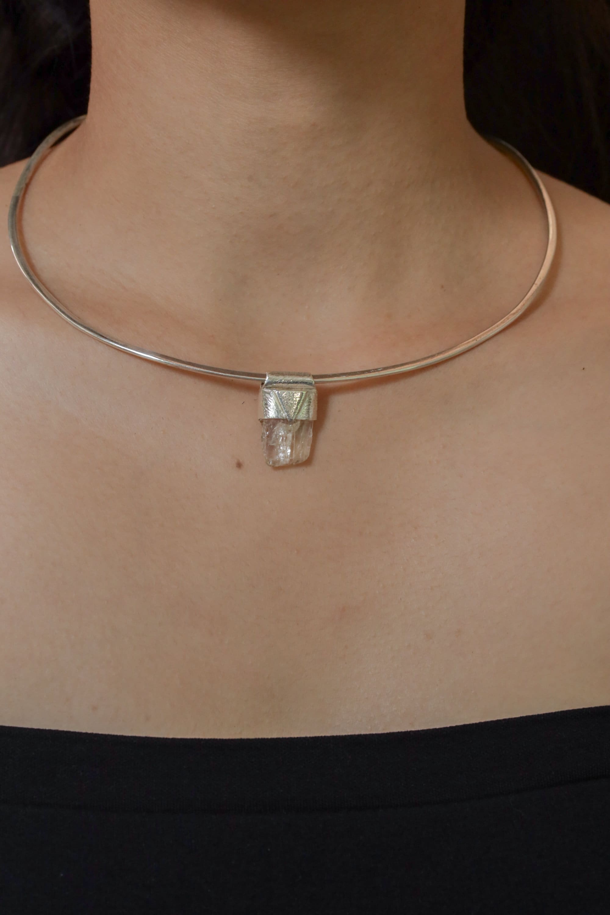 Clear Rainbow Inclusion Spodumene Stack Pendant shown worn on the chest with sterling silver cap and compact crystal body.