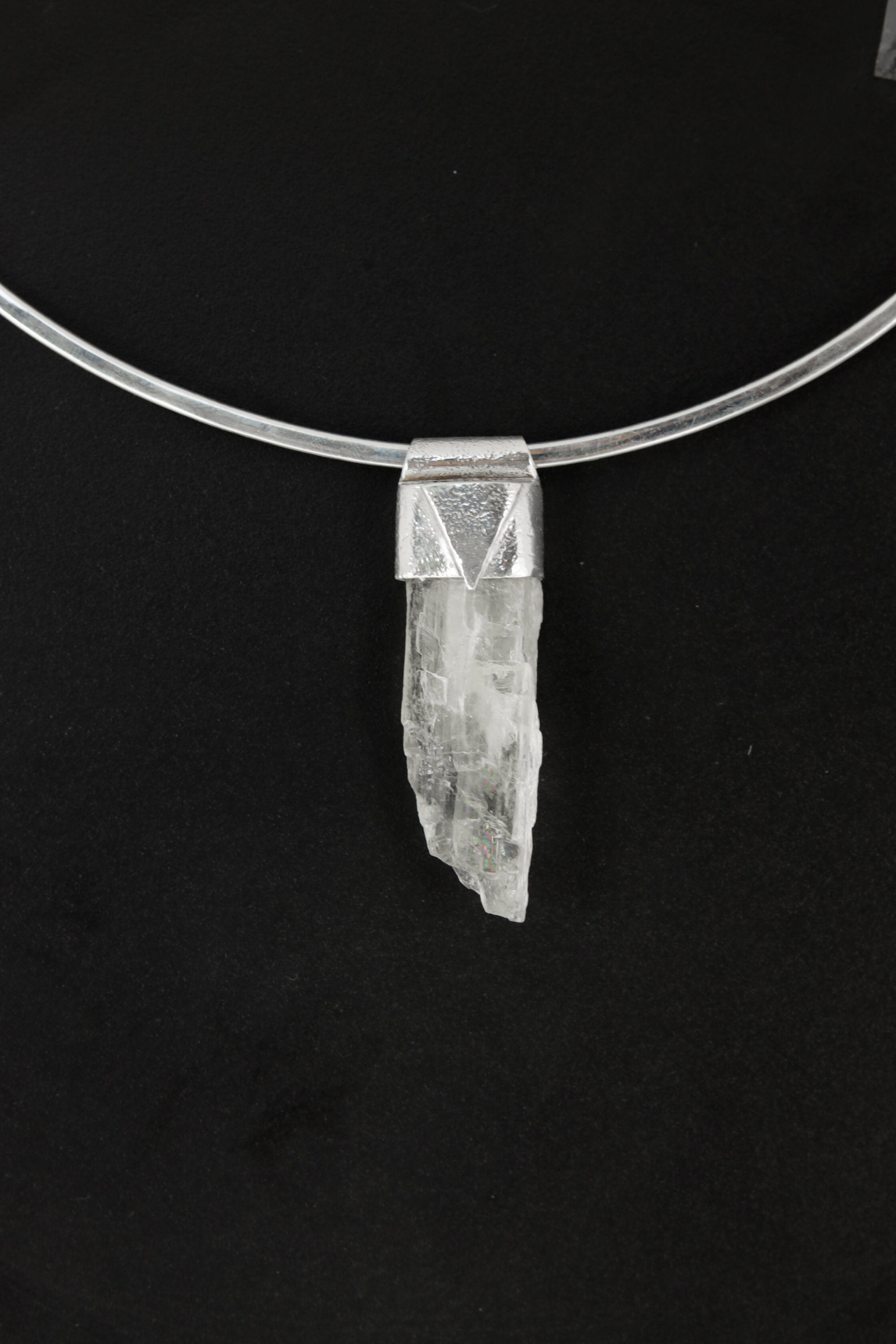 Hiddenite Stack Pendant shown on black background with sterling silver cap and pale green Spodumene crystal.