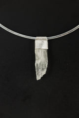 Hiddenite Stack Pendant shown on black background with hand-textured sterling silver cap and raw green crystal.
