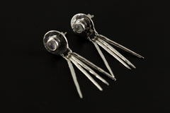 Handmade 925 sterling silver Blue Moonstone drop earrings shown on a dark background, with hammered circle settings and silver stick dangles.
