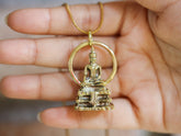 Gold-plated brass Bodhi pendant shown in hand, with sacred tree-inspired design and warm spiritual talisman finish.
